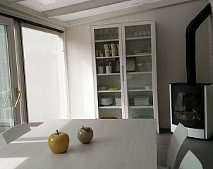 Lichte eetkamer met haard in Vakantiehuis Alegria, Westende, West-Vlaanderen.