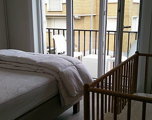 Slaapkamer met balkon en kinderbed in Vakantiehuis Alegria, Westende, Belgi.