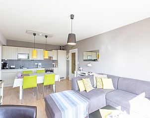 Helles Wohnzimmer des Ferienhauses Con Amore - 0403 in Westende, Belgien, mit moderner offener Kche und gemtlicher Sitzecke.