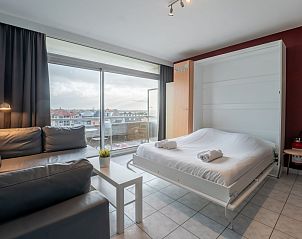 Cozy interior of Apartment Studio 502 in Bredene, West Flanders with comfortable bed and city view.
