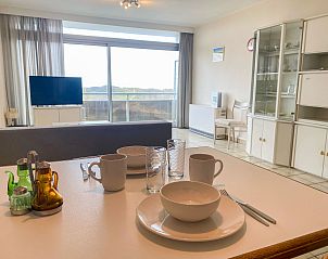 Cozy interior space of Apartment Residentie Astrid in Bredene, West Flanders, overlooking the coastline through large windows.