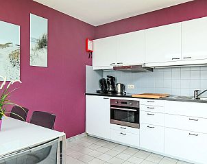 Moderne keuken in Appartement Studio 604, Bredene, West-Vlaanderen, Belgi met stijlvolle paarse muur en volledig uitgeruste voorzieningen.