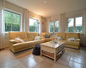 Gezellige woonkamer van vakantiehuis Frontzate in Diksmuide, West-Vlaanderen met comfortabele banken en veel natuurlijk licht.