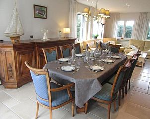 Gezellige eetkamer in vakantiehuis Frontzate te Diksmuide, West-Vlaanderen, met elegant gedekte tafel en uitzicht op de groene omgeving.