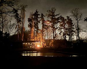 Sfeervolle avond bij Vakantiehuisje in Lokeren met verlichte omgeving en vijver, perfect voor een nachtelijke ontsnapping in Oost-Vlaanderen.