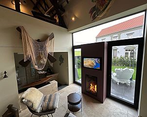 Gezellige binnenruimte van Vakantiehuis Einzigartiger Wellness-Bauernhof in Wichelen, Oost-Vlaanderen met open haard en tuinzicht.