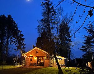 Sfeervol verlicht vakantiehuisje in Rillaar, Belgi bij nacht omringd door natuur.