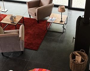 Stijlvolle woonkamer van Vakantiehuisje in Holsbeek met comfortabele zitplaatsen en warme sfeer, gelegen in Vlaams-Brabant, Belgi.