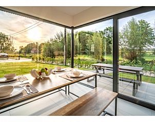 Eetruimte met uitzicht op de tuin bij VELPE55 vakantiehuis in Bierbeek, Vlaams-Brabant.