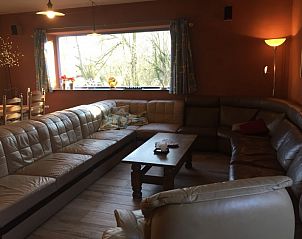 Gezellige woonkamer van Aan de Jordaan vakantiehuis in Willebringen, Vlaams-Brabant met comfortabele zithoek en uitzicht op de natuur.