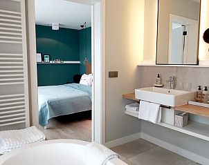 Luxe badkamer in Villa Veldzicht, Glabbeek met uitzicht op comfortabele slaapkamer.