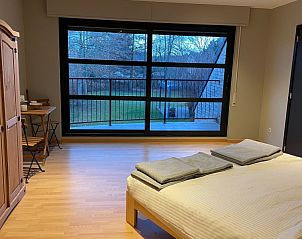 Slaapkamer in Wilgentuin, Bekkevoort, Vlaams-Brabant met groot raam en uitzicht op de tuin.