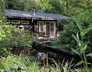 Rustieke veranda van Vakantiehuisje in Laakdal, Antwerpen, Belgi met uitzicht op een serene vijver.