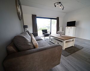Gezellige woonkamer in Chalet in Mol, Antwerpen, Belgi met comfortabele bank, moderne inrichting en uitzicht op de tuin.