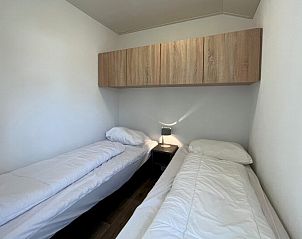 Gezellige slaapkamer in Chalet in Mol, Antwerpen, Belgi met twee comfortabele eenpersoonsbedden en moderne houten opbergruimte.