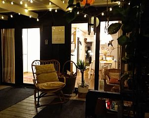 Atmospheric evening lighting on the terrace of Cottage in Oud-Turnhout, vacation home in Antwerp, Belgium, overlooking the indoor area.