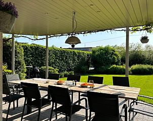 Gezellig terras met eettafel in Vakantiehuisje in Malle, Antwerpen, omringd door natuur, ideaal voor een ontspannen vakantie.