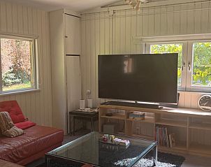 Gezellige woonkamer in Vakantiehuis in Essen Wildert, Antwerpen, Belgi met comfortabele zitruimte en groot raam met uitzicht op de tuin.