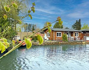 Fonnies Chalet in Geel, Antwerpen biedt rustieke charme aan het water, omgeven door natuur en een uitnodigend terras voor ontspanning.
