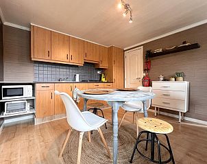 Gezellige keuken in Fonnies Chalet, een vakantiehuis in Geel, Antwerpen, Belgi, met moderne houten kasten en een uitnodigende eethoek.