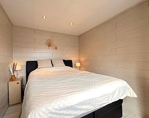 Gezellige slaapkamer in Fonnies Chalet, een vakantiehuis in Geel, Antwerpen, Belgi, met sfeervolle verlichting en moderne houten wanden.