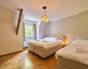 Spacious bedroom in Villa Bosrijk, Lommel, with comfortable bed and view of nature.