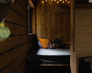 Gemtliches Schlafzimmer im Comfort Sweet Wellness Ferienhaus, Maaseik, Limburg, Belgien, mit schnen Holzwnden und sanfter Beleuchtung.