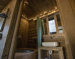 Gemtliches Badezimmer im Comfort Sweet Wellness Ferienhaus, Maaseik, Limburg, Belgien, mit Holzinterieur und stimmungsvoller Beleuchtung.