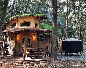 Hobbit House Ferienhaus in Maaseik, Limburg, Belgien mit rustikaler Terrasse und grner Umgebung.