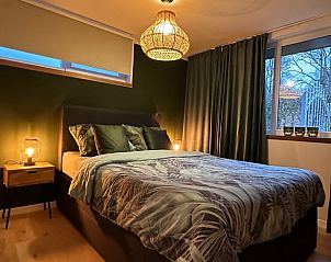 Attractive bedroom in Cottage in Lanaken, a vacation home in green Lanaken, Limburg, Belgium, with luxurious bed and warm lighting.