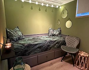 Cozy bedroom in Cottage in Lanaken, a vacation home in Lanaken, Limburg, Belgium, with atmospheric lighting and comfortable furnishings.