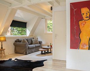 Gemtliches Wohnzimmer im Ferienhaus in Lanaken, Limburg, Belgien mit Kunstwerken und bequemer Sitzecke.