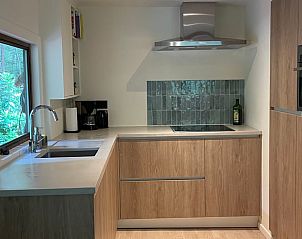 Moderne Kche in Cottage in Lanaken, Ferienhaus in Lanaken, Limburg, Belgien, mit Holzschrnken und einem stilvollen Herd.