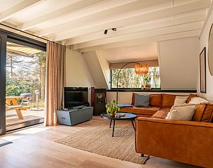 Cozy living room in Holiday Home in Lanaken, Limburg, Belgium with comfortable sofa and garden view.