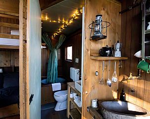 Knusse slaapkamer en badkamer van Sweet Cabin in Neeroeteren, Limburg, met sfeervolle houten inrichting.