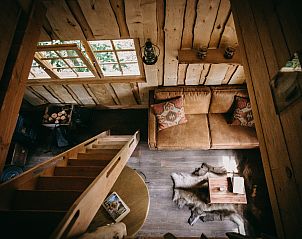 Bovenaanzicht van de gezellige woonkamer in Tree House 2, Neeroeteren, Limburg, Belgi, met rustieke houten elementen.