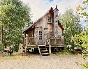 Zugang zum Baumhaus 1 in Neeroeteren, Limburg, Belgien, ber einen Holzsteg zwischen den Bumen.
