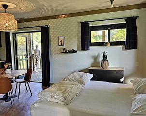 Slaapkamer en keuken in Comfort Studio (3p), een vakantieverblijf in Neeroeteren, Limburg met toegang tot terras.