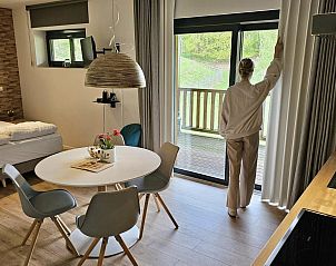 Gemtlicher Innenbereich der Connecting Rooms in Neeroeteren, Limburg, Belgien, mit Blick auf die grne Umgebung von der Terrasse aus.