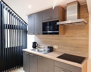 Moderne Kche des Ferienhauses Classic Studio in Neeroeteren, Limburg, Belgien, mit glatter Oberflche und natrlichem Licht.