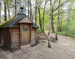berdachte Veranda von Comfort Classic in Neeroeteren, Limburg, Belgien, mit Holzsitzgruppe und Grill, umgeben von Natur.