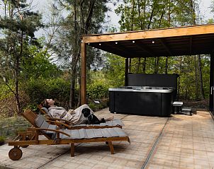 Ontspan op het terras van Comfort Sweet Wellness vakantiehuis in Neeroeteren, Limburg met jacuzzi en groene omgeving.