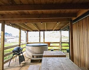 Ontspan op de veranda van Vakantiehuis in Maaseik in Neeroeteren, Limburg, Belgi met uitzicht op groene velden en een luxe hot tub.
