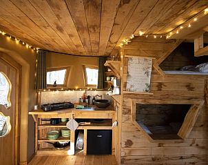 Gezellige binnenruimte van Huisje in Maaseik, een vakantiehuis in Neeroeteren, Limburg, met houten interieur en sfeerverlichting.