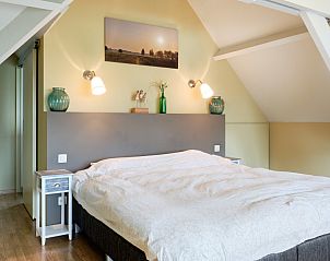 Lichte zolderkamer in Pietershuis vakantiehuis, Kinrooi, met comfortabel bed en rustgevende ambiance.