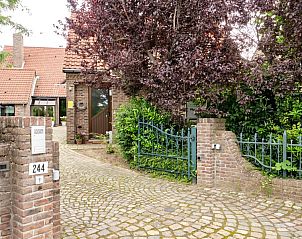 Ingang van Pietershuis vakantiehuis in Kinrooi, Limburg, met groene tuin en charmante stenen poort.
