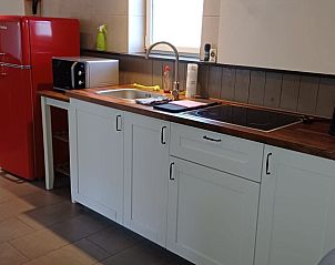 Gezellige woonkamer met uitzicht op terras in Aan Maas & Grens vakantiehuis in Kinrooi, Limburg, Belgi.