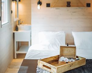 Gezellige slaapkamer in Vakantiehuis in Kinrooi, Limburg, Belgi met houten interieur en comfortabele voorzieningen.