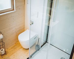 Moderne douche en toilet in Vakantiehuis in Kinrooi, Limburg, Belgi met strak design en houten afwerking.