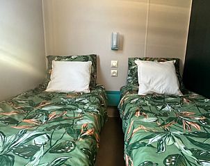 Sfeervolle slaapkamer in Huisje in Kinrooi, vakantiehuis in Limburg, Belgi met twee comfortabele bedden.